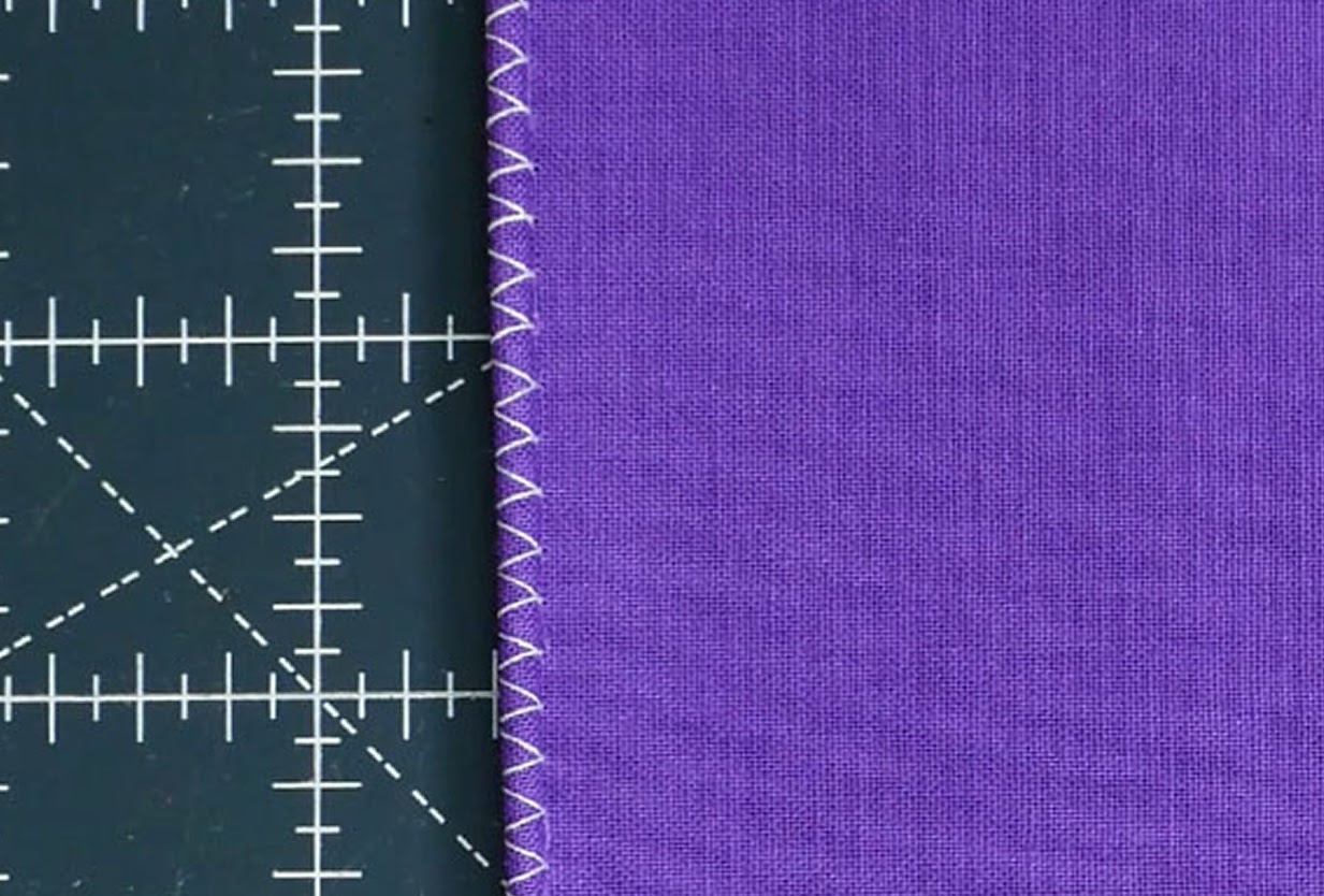 Close-up of a hemmed piece of purple fabric.