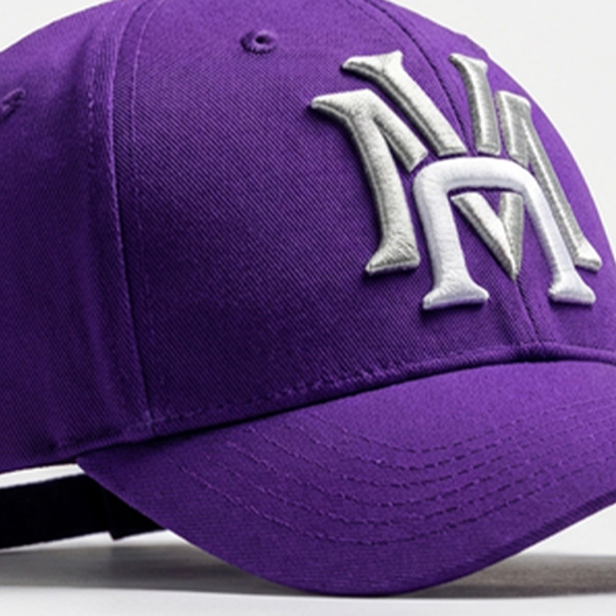 Purple cap with an embroidered emblem in white and with a 3D effect.