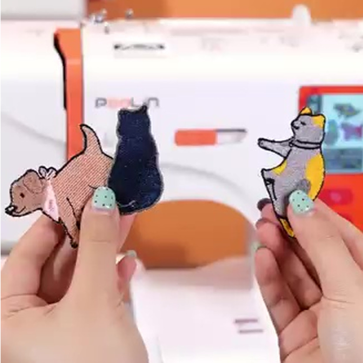 Embroidered patches of two cats and a dog.