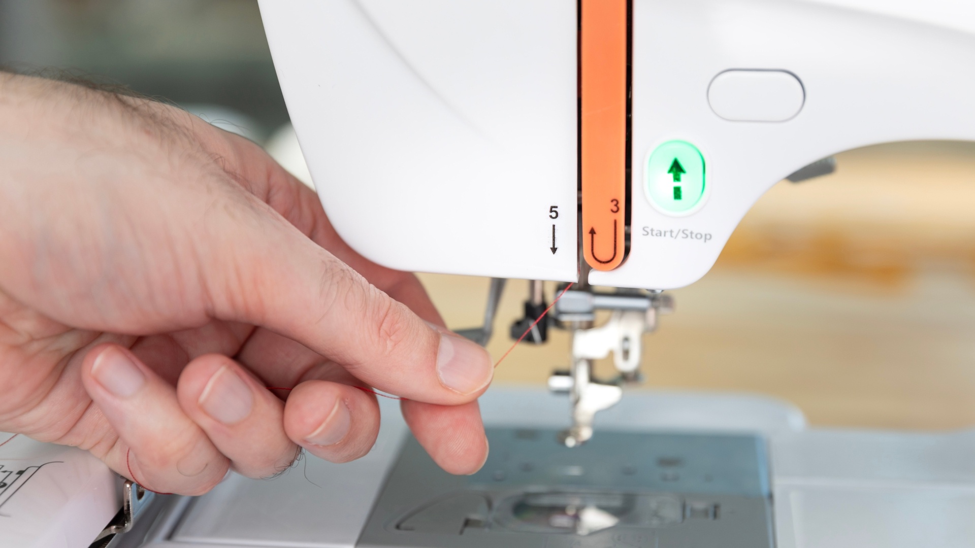 Step 5: pull the thread all the way down on the left side of the orange guide