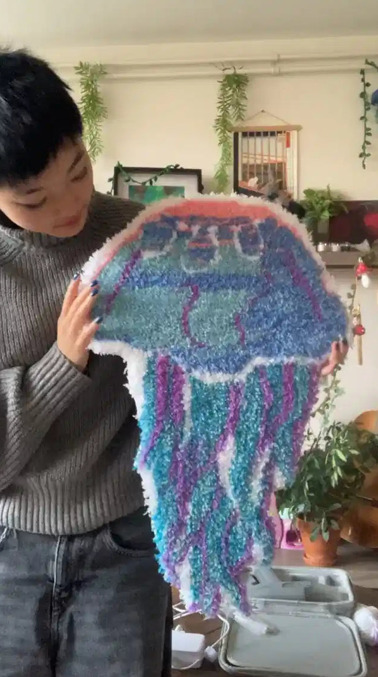 Woman holding a tufted rug of a jellyfish.