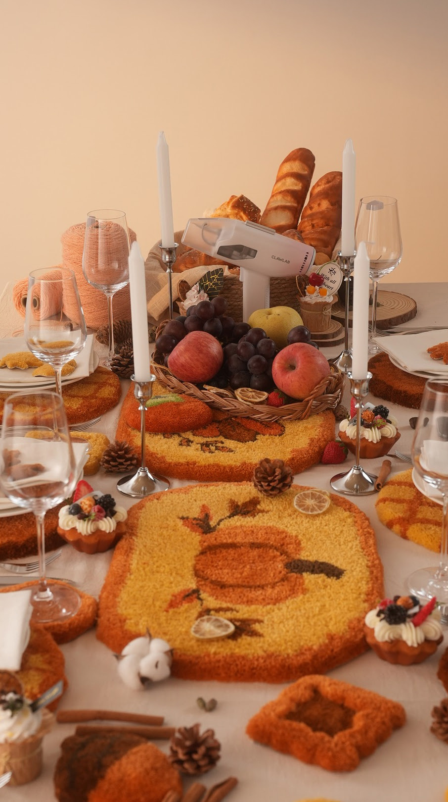 Thanksgiving table setting with tufted placemats with pumpkin designs in yellow, brown and orange.