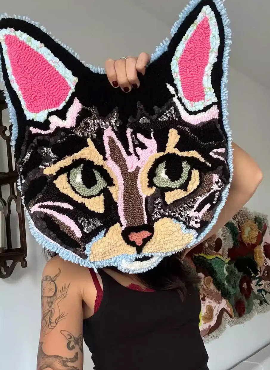 Tufted rug of a giant cat head.
