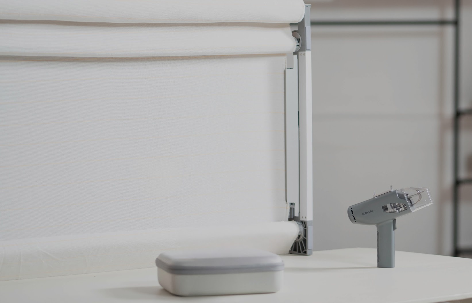 Clawlab Tufting Frame H1 with fabric stretched on it. In front are the Tufting Gun H1 and the carry case.