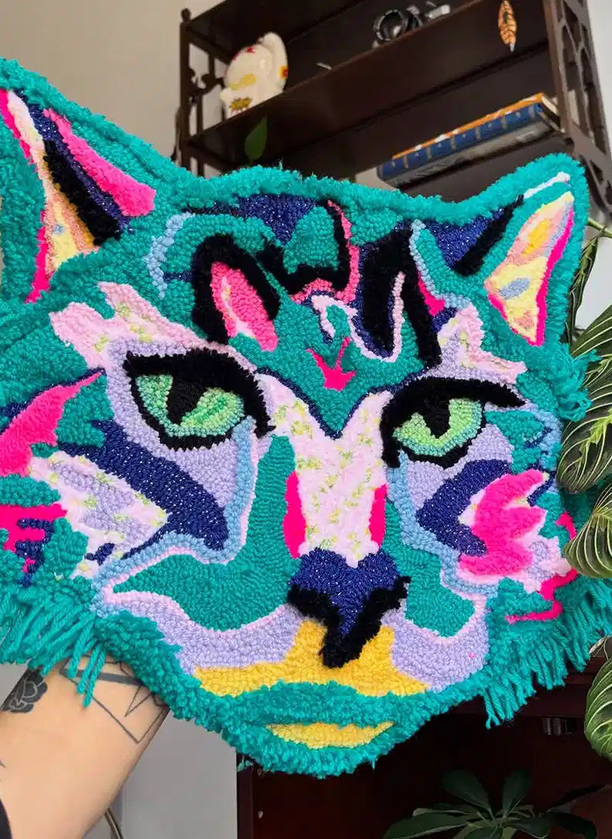 Tufted rug of a colourful cat head.
