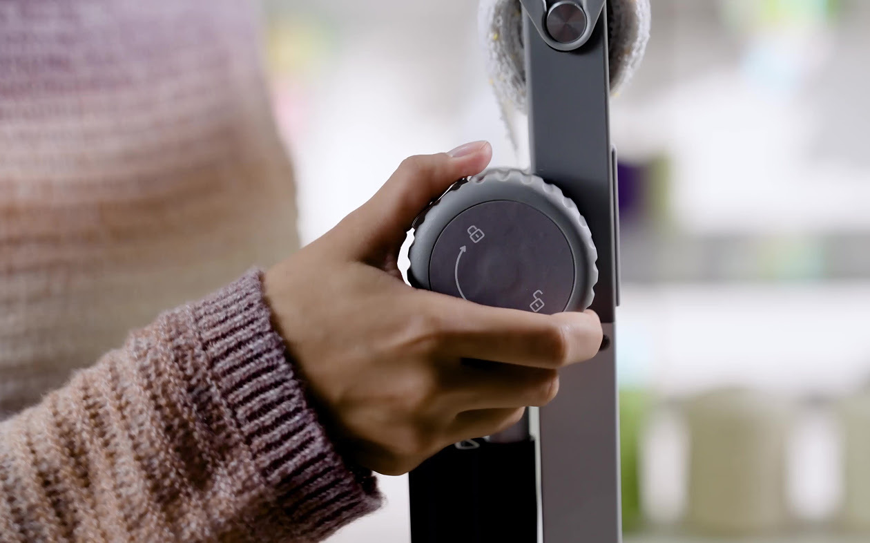 Hand tightening the fabric using the tensioning switch.