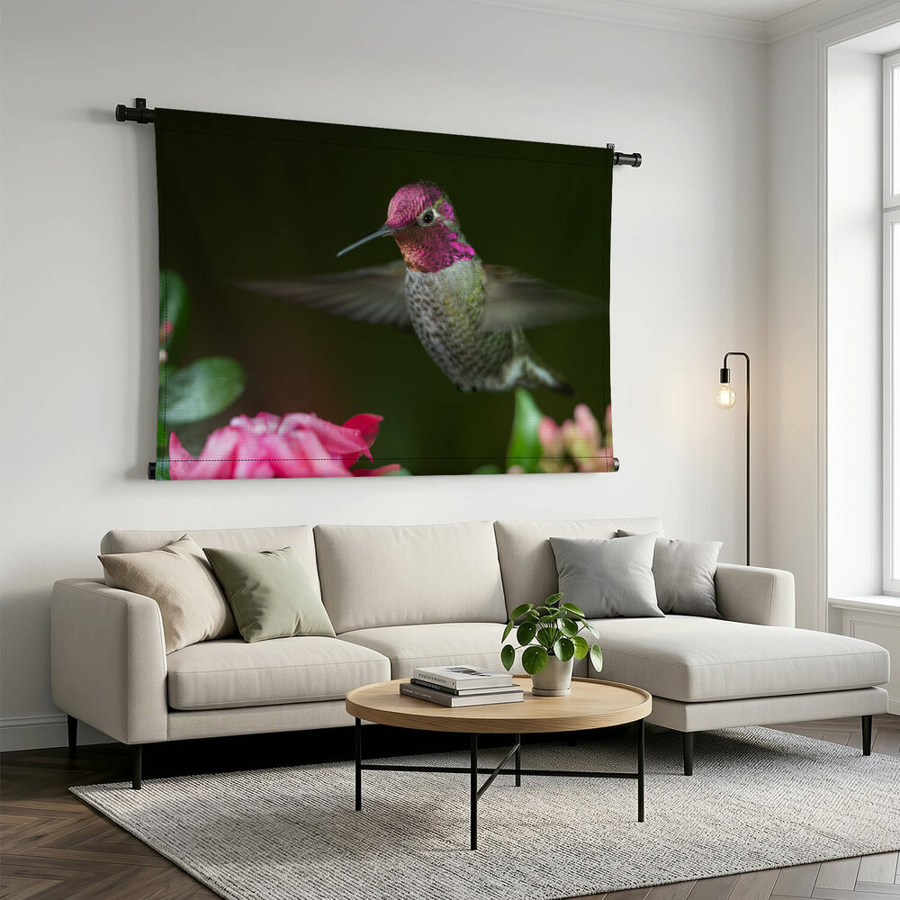 Kolibrie zwevend bij roze bloemen