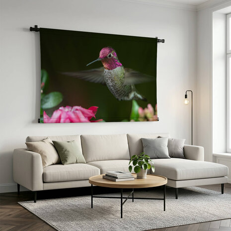 Kolibrie zwevend bij roze bloemen