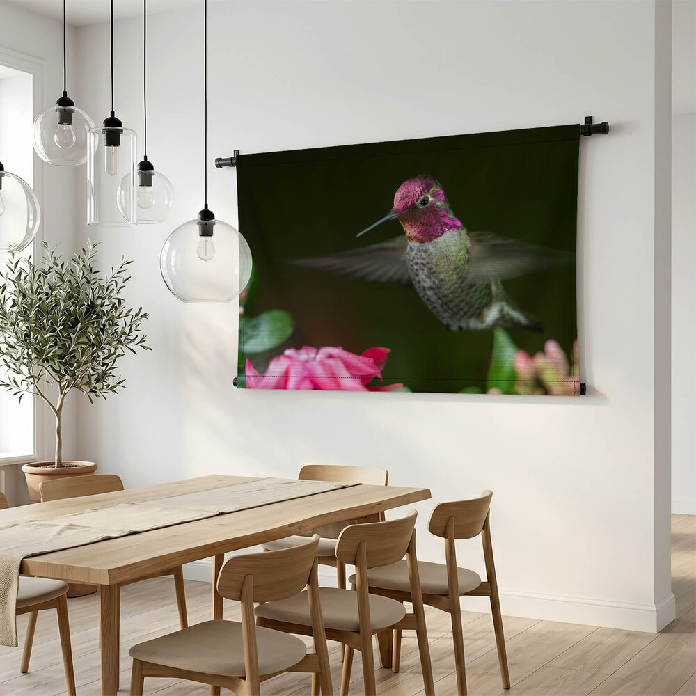 Kolibrie zwevend bij roze bloemen