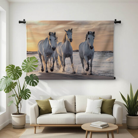 Kudde witte paarden op het strand