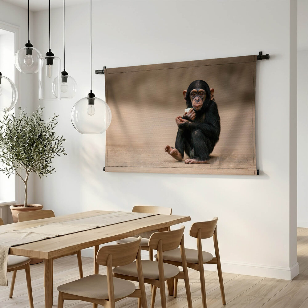 Jonge chimpansee gehurkt op de grond