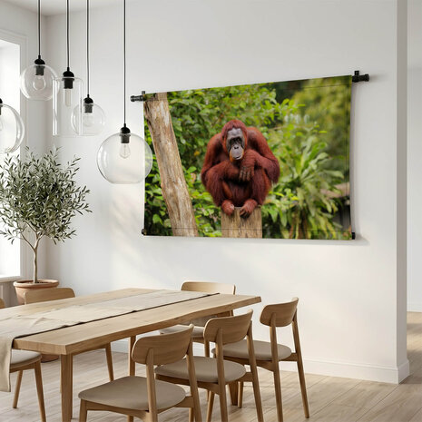 Orang-oetan zittend op boomstronk