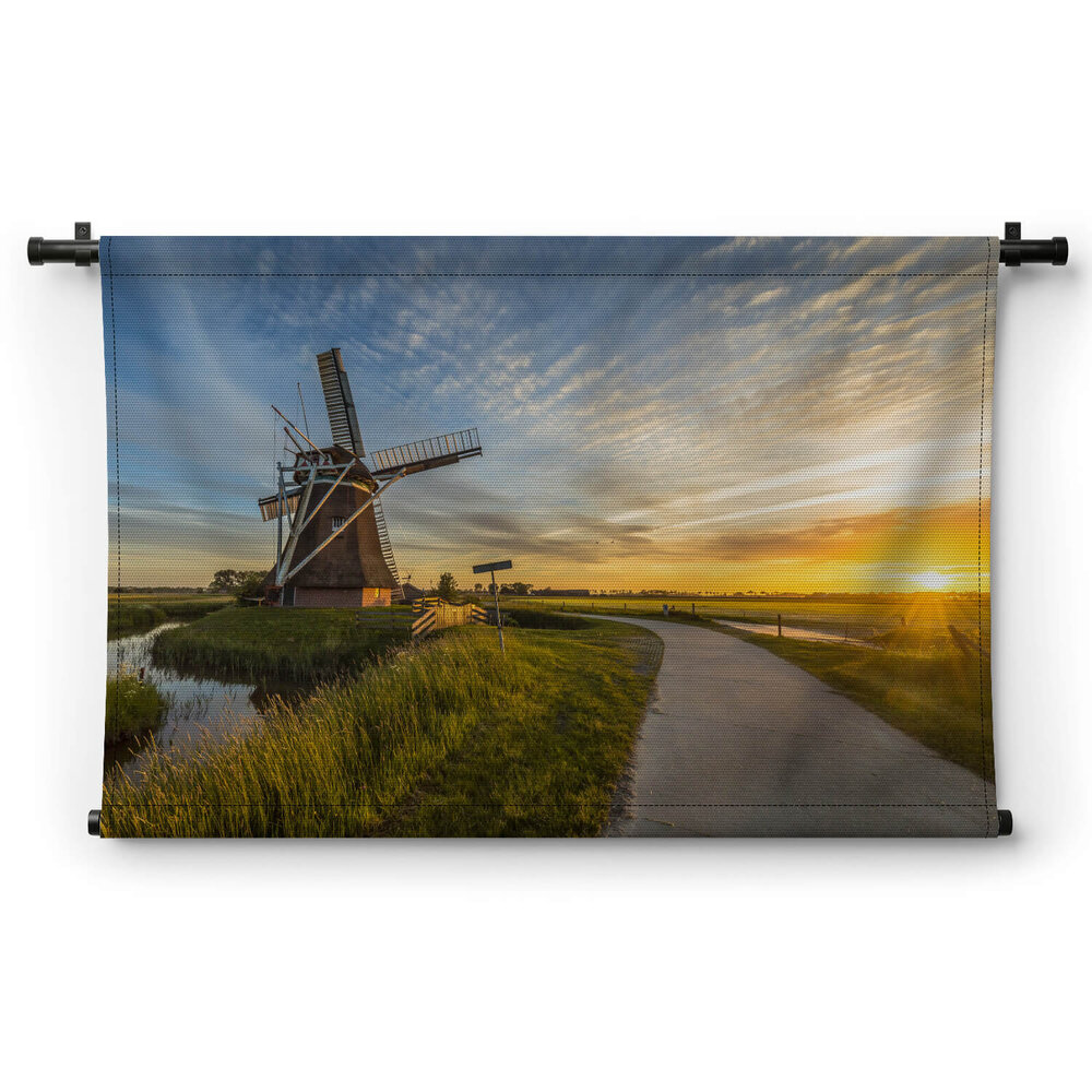 Houten windmolen bij zonsondergang
