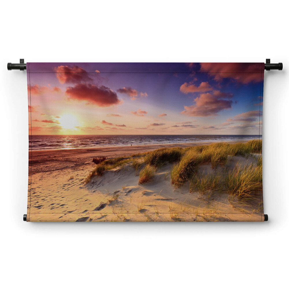 Kust met zandduinen bij zonsondergang