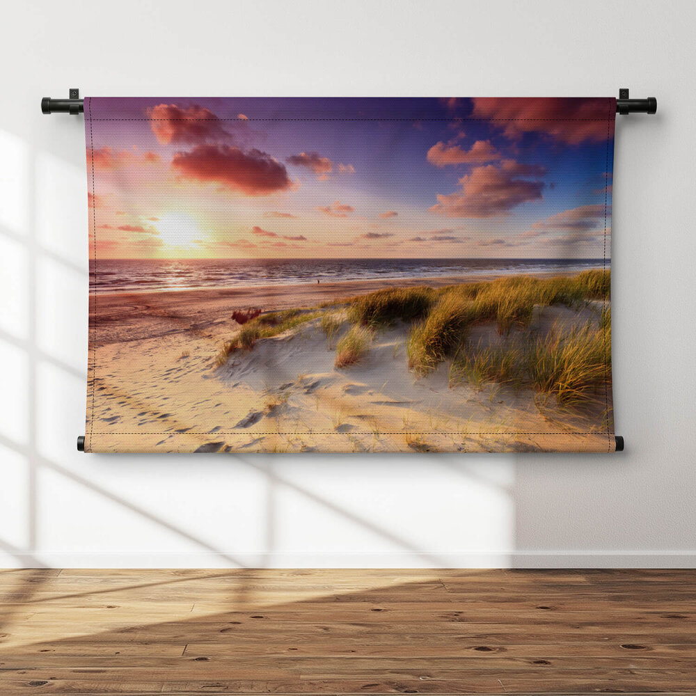 Kust met zandduinen bij zonsondergang