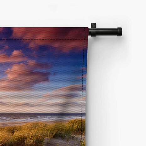 Kust met zandduinen bij zonsondergang
