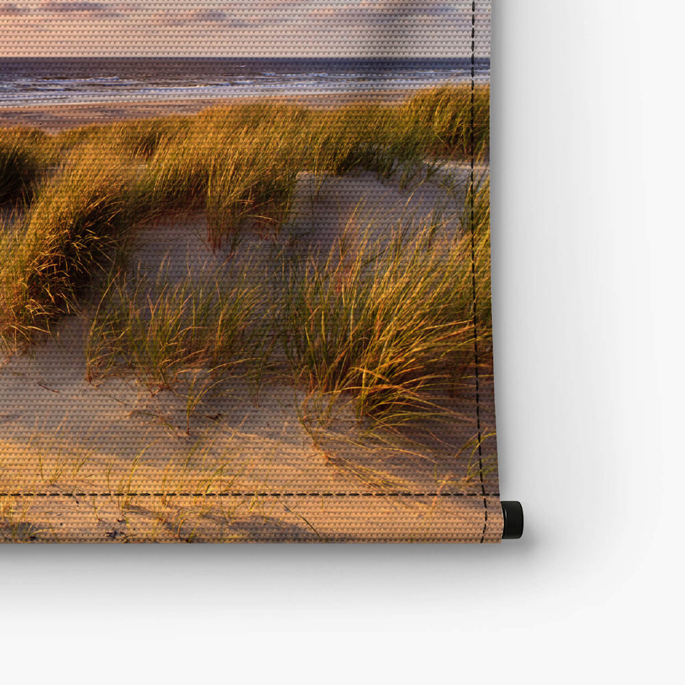 Kust met zandduinen bij zonsondergang