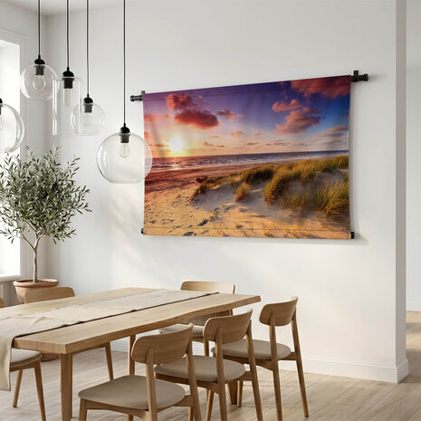 Kust met zandduinen bij zonsondergang