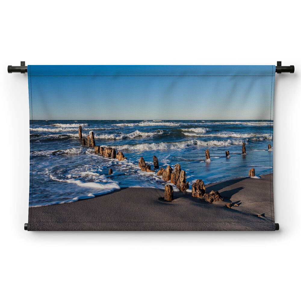Versleten meerpalen op het strand