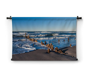 Versleten meerpalen op het strand