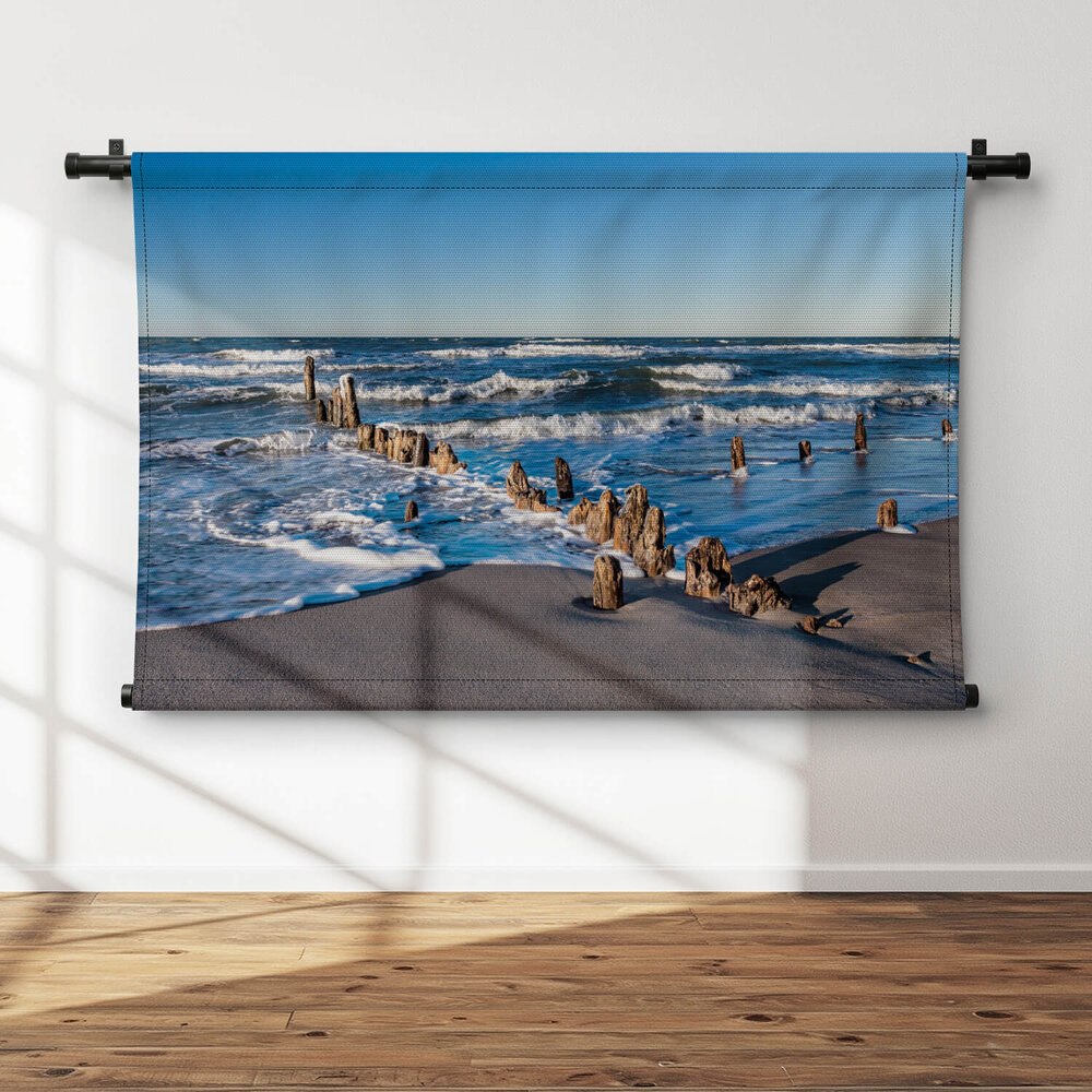 Versleten meerpalen op het strand