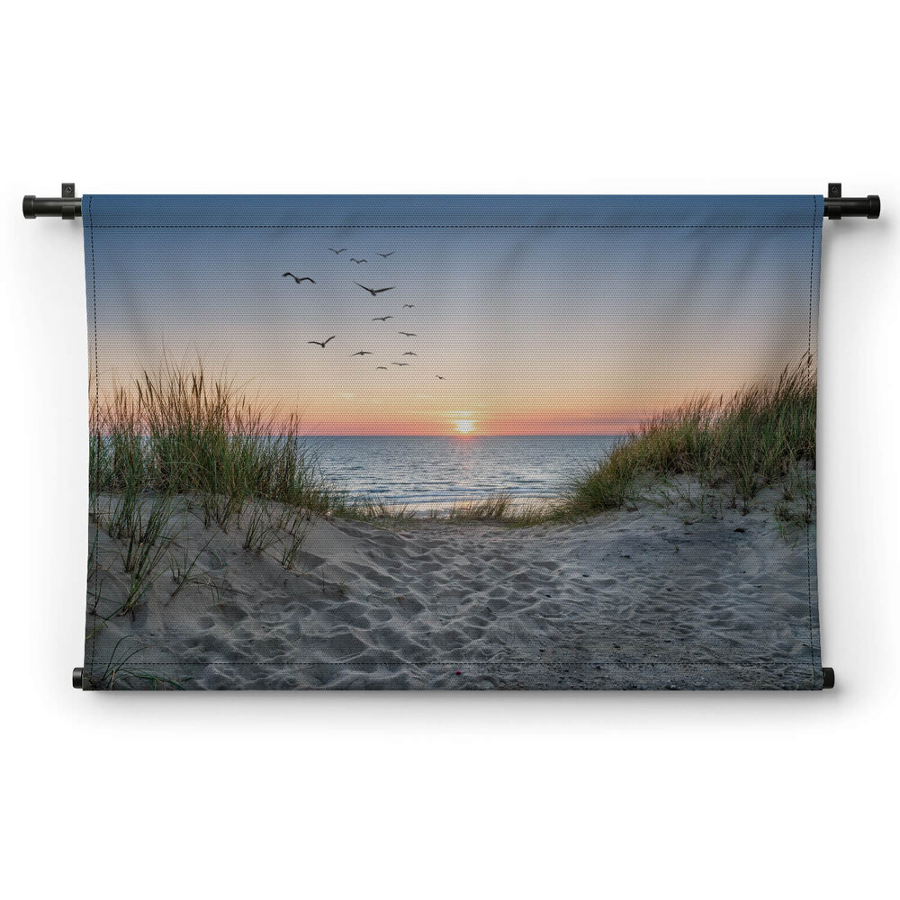 Zandduinen op het strand bij zonsondergang