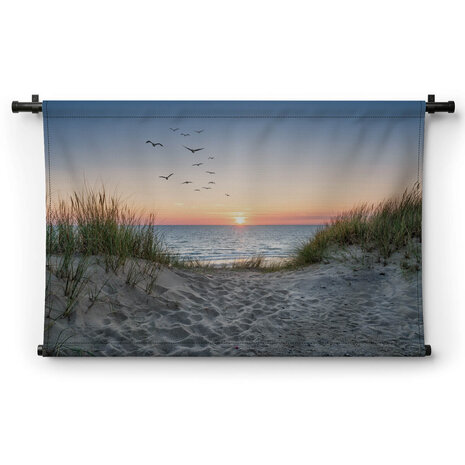 Zandduinen op het strand bij zonsondergang