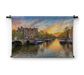 Amsterdamse skyline bij zonsondergang aan de gracht