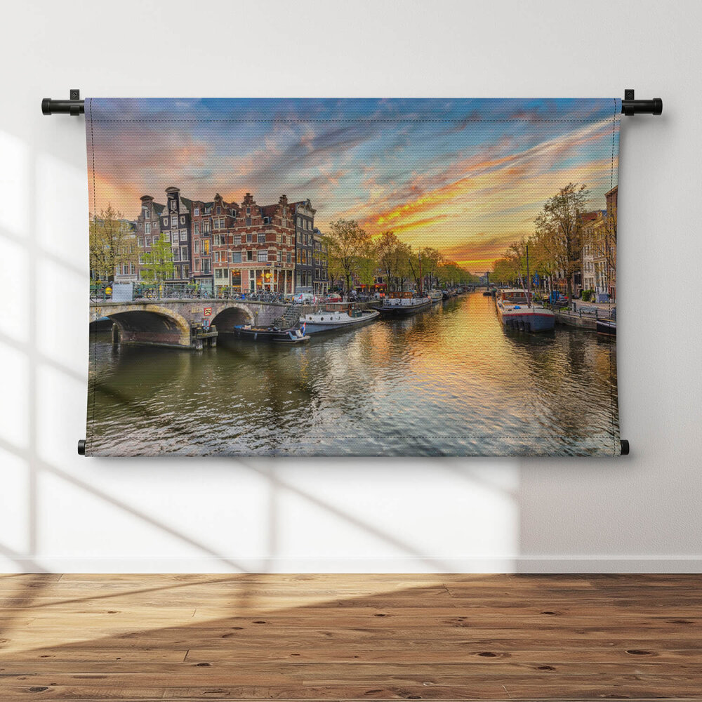 Amsterdamse skyline bij zonsondergang aan de gracht