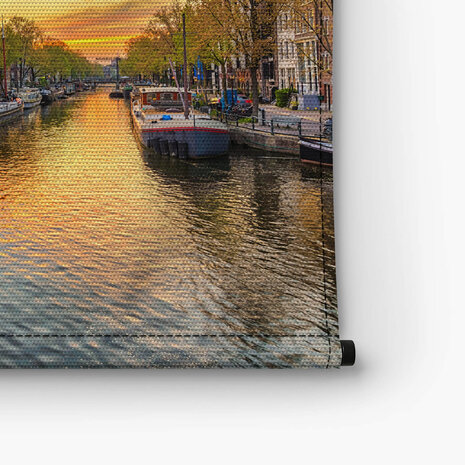 Amsterdamse skyline bij zonsondergang aan de gracht