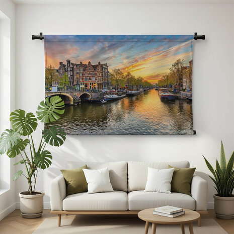 Amsterdamse skyline bij zonsondergang aan de gracht
