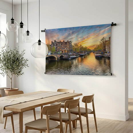 Amsterdamse skyline bij zonsondergang aan de gracht