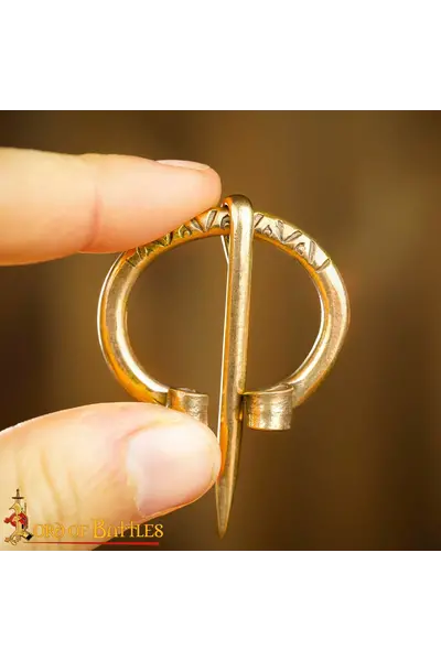 Early medieval brass horseshoe fibula