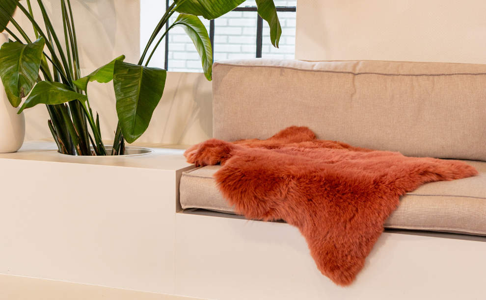 Oranje Nieuw-Zeelands schapenvacht op de bank