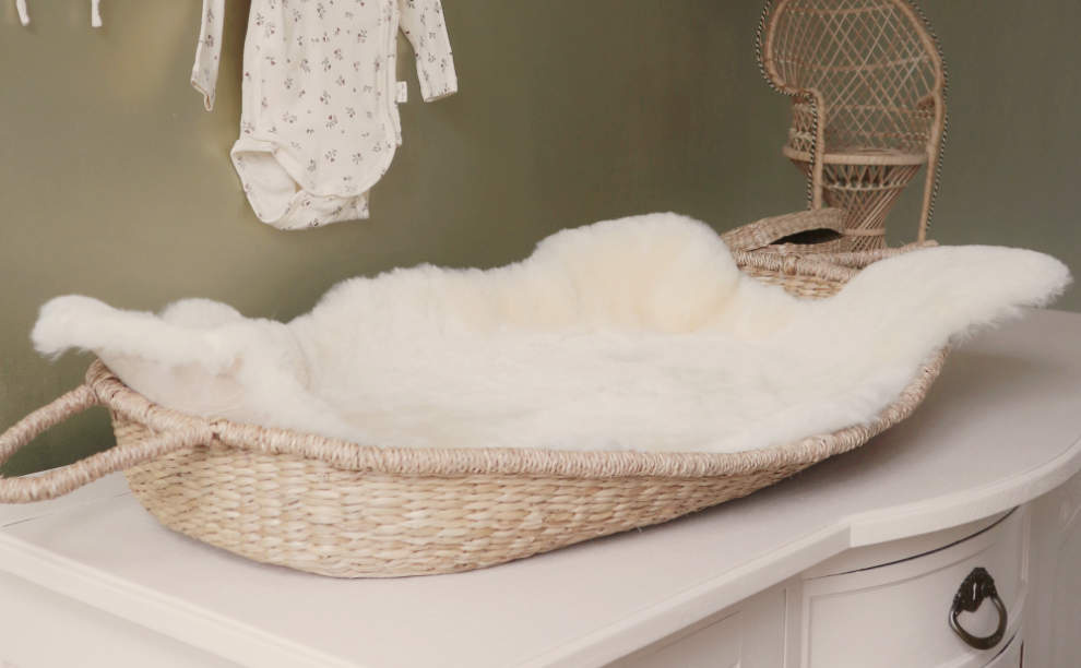 Lamsvacht baby schapenvacht in rieten verschoonmand