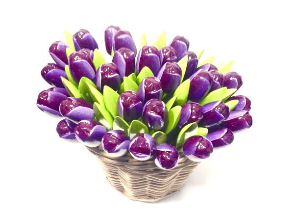 dunkelviolette hölzerne Tulpen in einem Weidenkorb