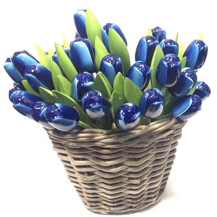 Blauwe houten tulpen in een rieten mand