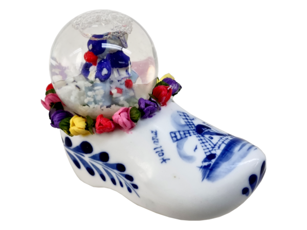 Snow globe with a kissing couple on a clog