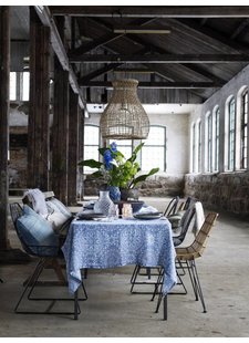 Superbe table et sa décoration, avec un mix de chaises en métal, rotin et bois. Au-dessus de la table, une suspension naturelle.