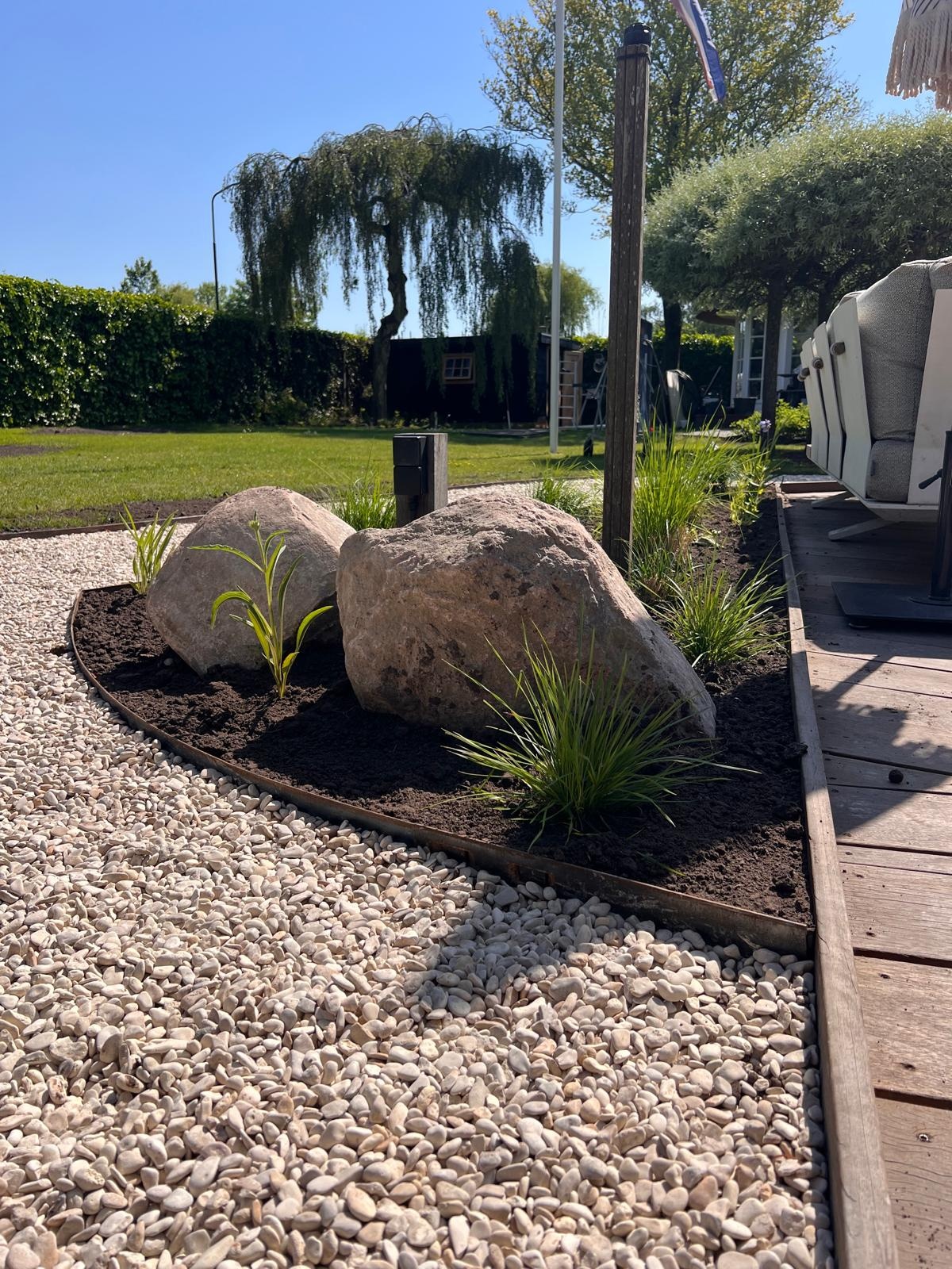 Granieten zwerfkeien in een border met planten