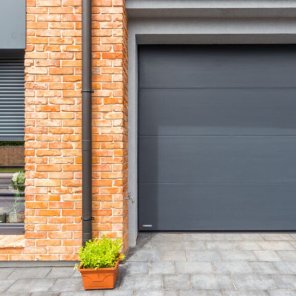 Moderne geïsoleerde garagedeur in een gemetselde woning