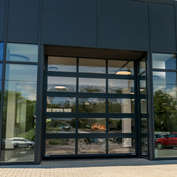 Transparante industriële aluminium sectionaaldeur in een bedrijfspand