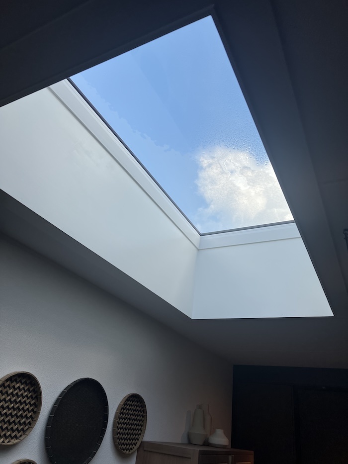 Vast platdakraam boven een lichte woonkamer