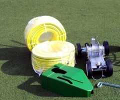 Chariot d'irrigation professionnel King pour terrains de football, comprenant tuyaux et accessoires.