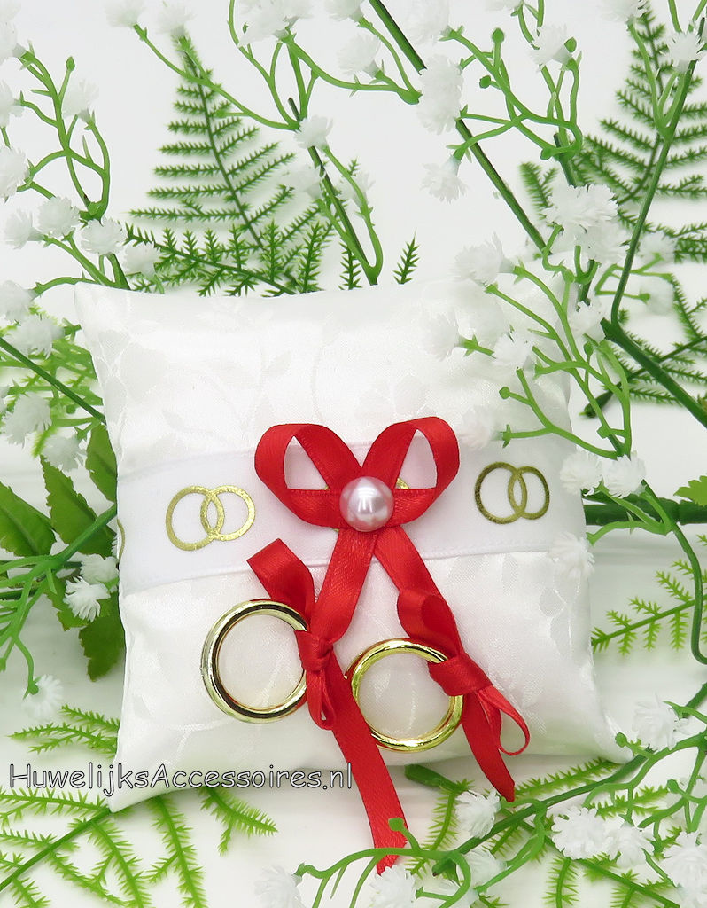 Ringkussentje voor je hond versierd met rode lint en gouden ringen