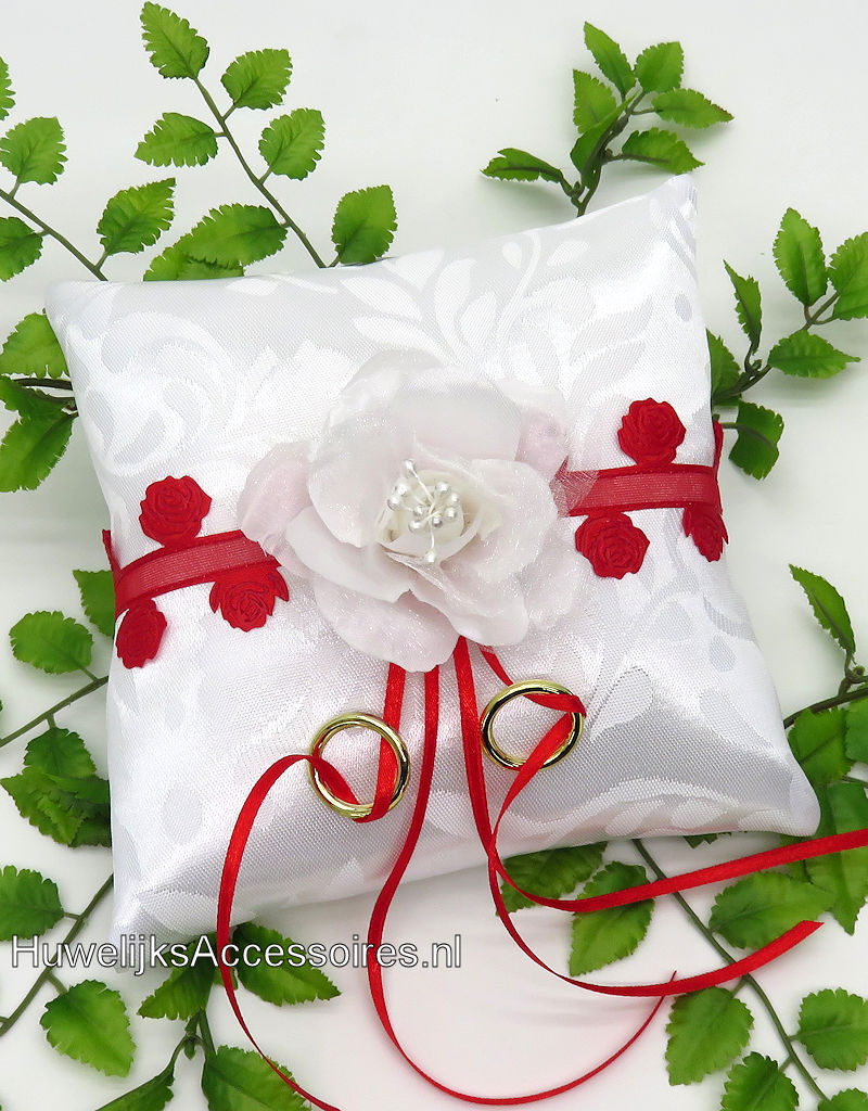 Witte trouwringen kussen met rood en wit rozen