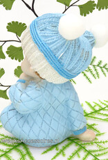 Zittende baby jongetje met beertje in blauwe pyjama