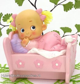 Meisje ligt in haar bedje met roze pyjama