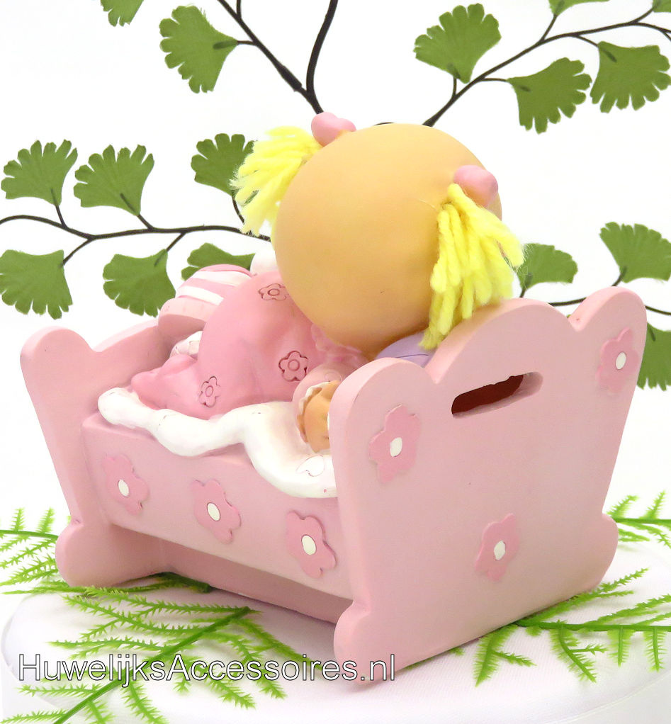 Leuke baby meisje ligt in haar bedje met een roze pyjama aan