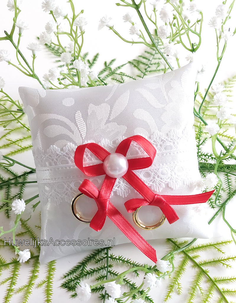 Ringkussen voor de hond versierd met rode lint en kant